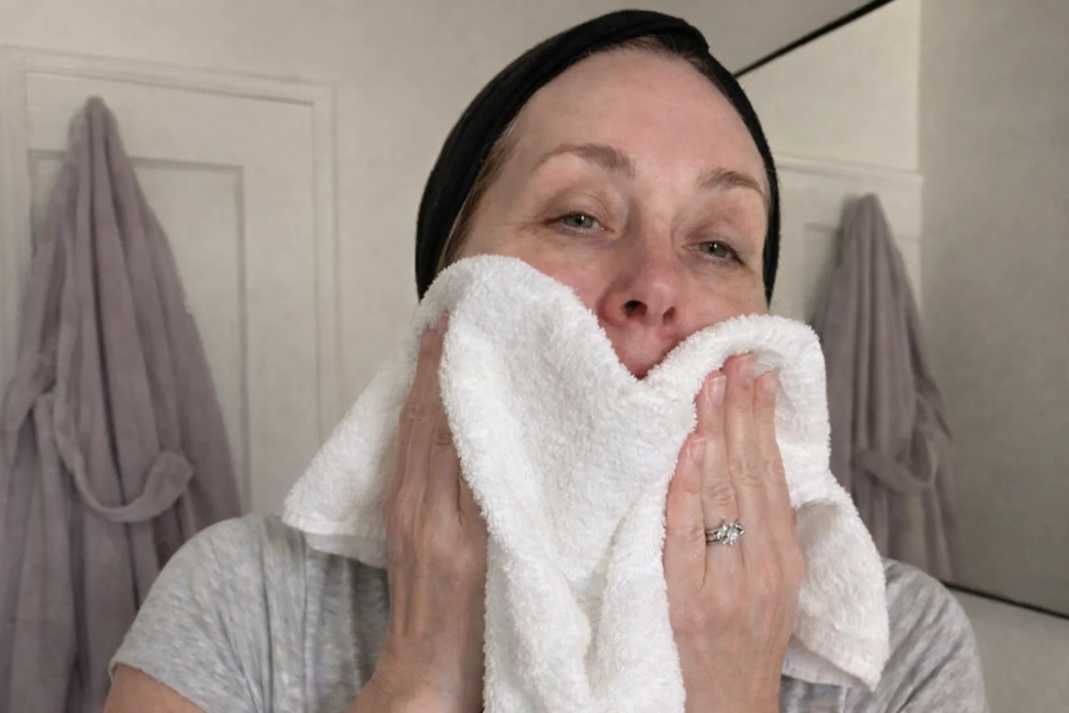 Patting the face dry with a clean towel before application
